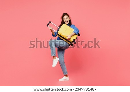 Traveler woman wears blue shirt casual clothes hold suitcase pov play guitar isolated on plain pink background. Tourist travel abroad in free spare time rest getaway. Air flight trip journey concept Royalty-Free Stock Photo #2349981487