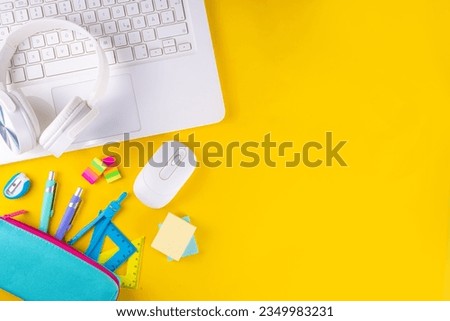Back to school, online education high-colored bright yellow background. White laptop with school education supplies, headphones, pencil case and accessories top view flat lay copy space