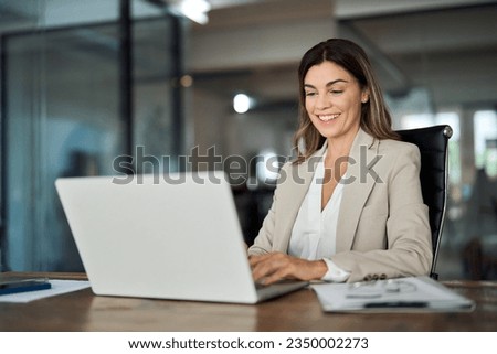 Happy mature business woman entrepreneur in office using laptop at work, smiling professional middle aged 40 years old female company executive wearing suit working on computer at workplace. Royalty-Free Stock Photo #2350002273
