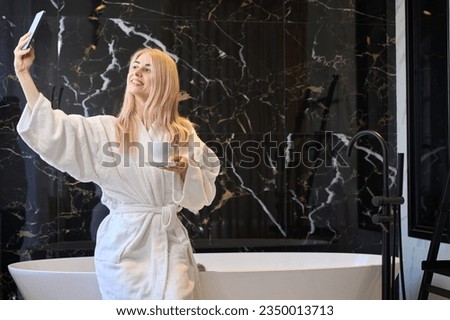 Positive woman bragging with luxury hotel apartment making selfie