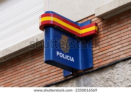 On the building hangs a sign with the inscription Police and the flag of Spain.