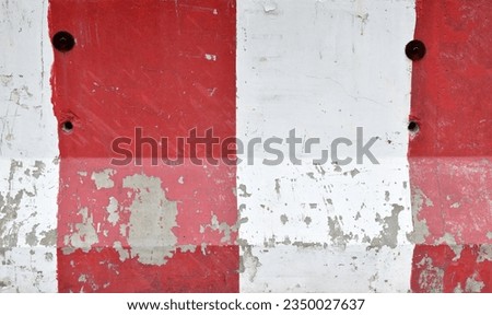 closeup grunge concrete barrier texture for background, red and white paint striped cements roadblock with scratched and peeled, traffic border sign