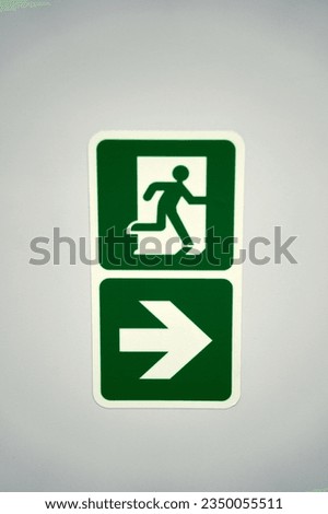 emergency fire exit sign with running man icon to door. warning sign plate