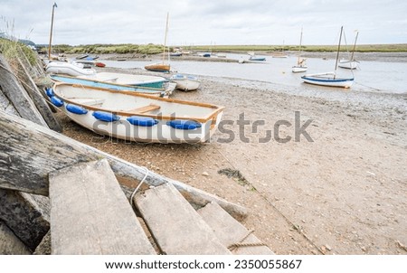 Wooden steps lead down to the shore and boats at Burnham Overy Staithe on the North Norfolk coast pictured in August 2023.