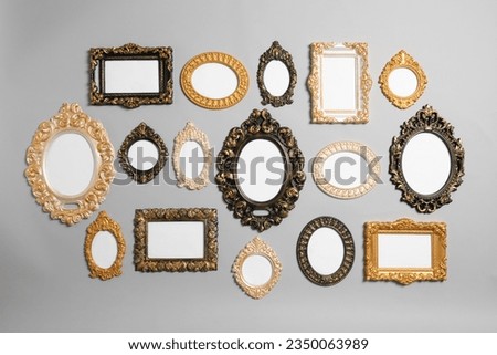 Empty vintage frames hanging on light gray wall