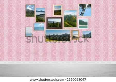 Many beautiful landscapes in frames on striped wall in room