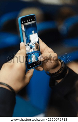 Student taking a photo of the presentation while attending a lecture