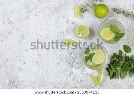 Detox drink with mint, lime and orange on a light table, majito or cocktail improves metabolism and promotes weight loss, healthy lifestyle concept,