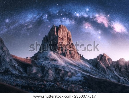 Milky Way acrh over beautifull rocks at starry night in autumn in Dolomites, Italy. Landscape with purple sky with stars and bright arched milky way over high alpine rocky mountains. Space. Nature Royalty-Free Stock Photo #2350077517