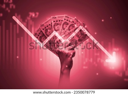 Hand holding Yuan banknote with decreasing arrow and stock market graph chart .It is symbol of china economy crisis concept. Royalty-Free Stock Photo #2350078779