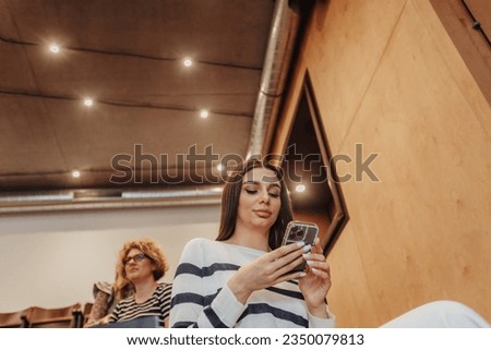 Low angle view photo of female employee using mobile phone during break at work