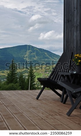 Outdoor wooden furniture on a terrace with mountain view in Ukraine