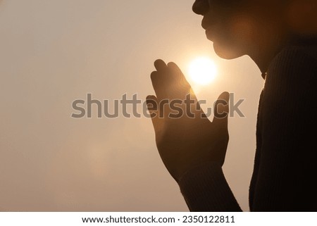 Silhouette of woman prayer position, Praying hands with faith in religion and belief in God on dark background. Power of hope or love and devotion. Namaste or Namaskar hands gesture. Royalty-Free Stock Photo #2350122811
