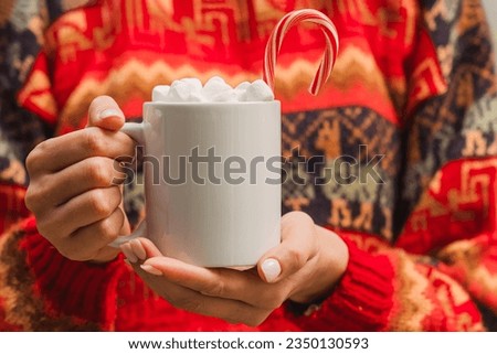 Woman in red sweater holding white cup with hot chocolate with marshmallow close-up. Christmas mug mock-up