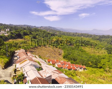 Bird's-Eye Cityscape with Dense Residential Area and Greenery. Aerial Drone Shot. Aerial view of a Residential district on the slopes of Mount Pangradinan. Bandung - Indonesia