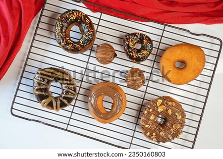different flavor of Donuts are placed on grill with black and white backgrounds respectively, yellow check napkin and red napkin, different flavors with close up shots. different variation available.