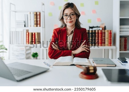 Portrait of a Asian woman lawyer studying lawsuit a for a client using computer laptop , documents to video conference before going to court
