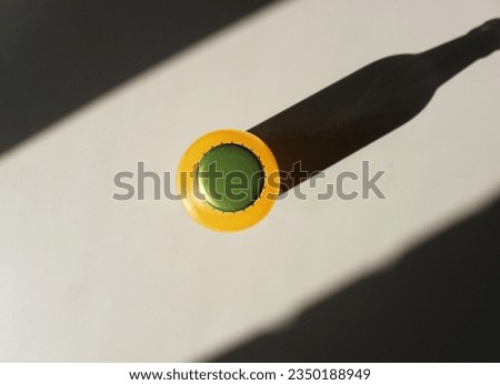 Lemonade Bottle and a Shadow on table view from above. Closeup Flat lay Photography for Banner, Promotion, Ptinting, Poster. Fresh and juicy non-alcoholic Summer drink.