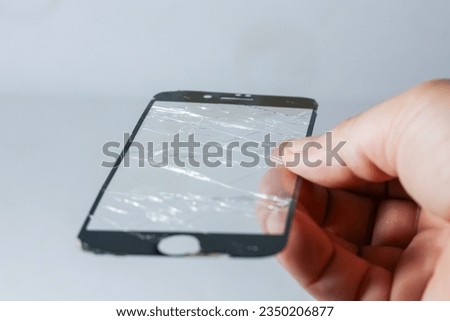 Glasses protect smartphones is broken.Hold broken glasses on hands with closeup in white background.