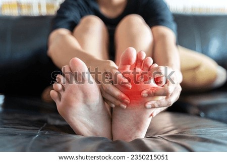 Foot pain, Asian woman feeling pain in her foot at home, female suffering from feet ache use hand massage relax muscle from soles in home interior, Healthcare problems and podiatry medical concept Royalty-Free Stock Photo #2350215051