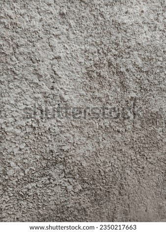 image of a worn and rough wall surface by the roadside of a village
