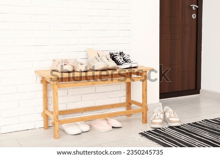 Stylish shoes and orthopedic insoles on wooden shoe rack in hallway Royalty-Free Stock Photo #2350245735