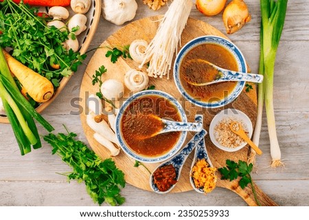Miso, ramen or vegetable broth with ingredients on wooden background