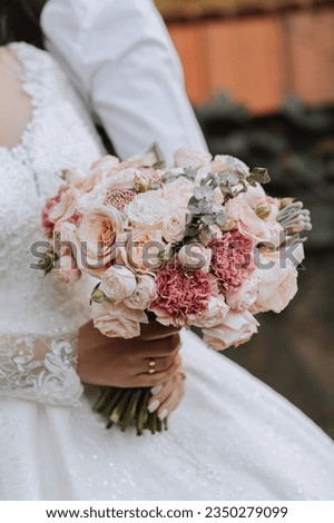 Portrait of the bride with a bouquet. A beautiful young bride holds a wedding bouquet in her hands. Wedding lace dress