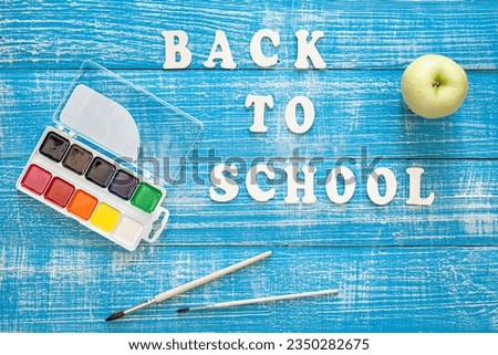 Back to school concept on wooden blue background, top view.