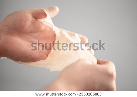Hand dipped container with paraffin. Paraffin Therapy.Treat those with beriberi hands. Chronic wrist fractures, cracked fingers, broken fingers.Rheumatoid arthritis, wrist fracture Royalty-Free Stock Photo #2350285883