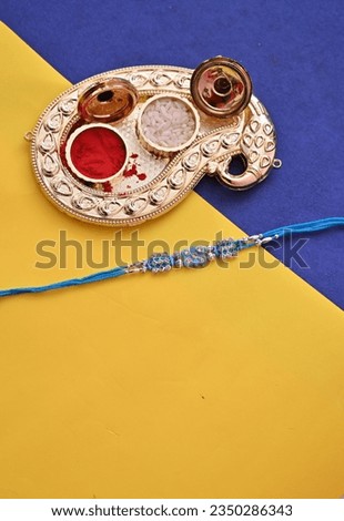 Raksha Bandhan, Indian festival with beautiful Rakhi on yellow and blue background. A traditional Indian wrist band which is a symbol of love between Sisters and Brothers.