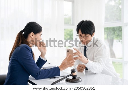 Attractive young lawyer in office Business man and lawyers discussing contract papers with brass scale on wooden desk in office. Law, legal services, advice, Justice and real estate concept.