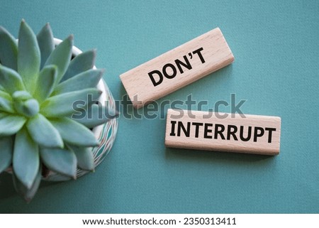 Dont interrupt symbol. Concept word Dont interrupt on wooden blocks. Beautiful grey green background with succulent plant. Business and Dont interrupt concept. Copy space