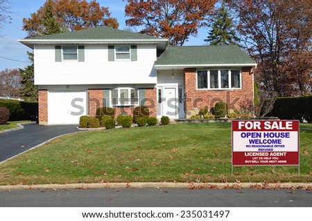 Real Estate For sale open house welcome sign front yard of Suburban Brick High Ranch home autumn day residential neighborhood clear blue sky USA