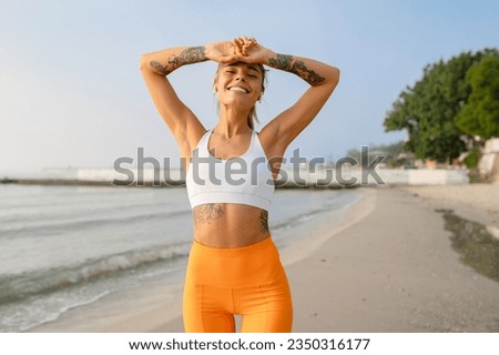 pretty young smiling woman doing sports in the morning by the sea beach in stylish sport outfit sportswear skinny strong body healthy fit lifestyle happy enjoying having fun Royalty-Free Stock Photo #2350316177