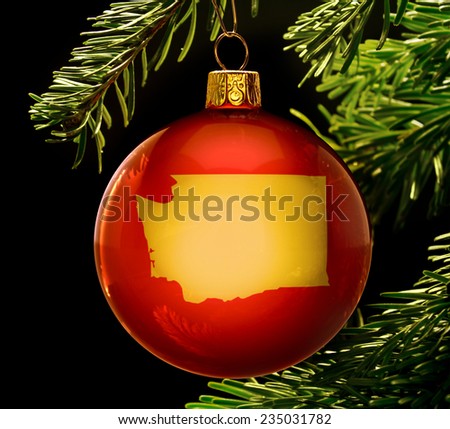 A red bauble with the golden shape of  Washington hanging on a christmas tree isolated on black.(series)