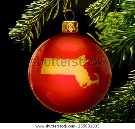 A red bauble with the golden shape of  Massachusetts hanging on a christmas tree isolated on black.(series)