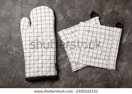 Wooden kitchen utensils, cutting board, potholder and glove on the table, top view. Kitchen Mitten and protective oven mitts on the table. Kitchenware. Kitchen accessories.Close-up.top view.