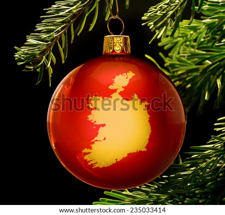 A red bauble with the golden shape of  Ireland hanging on a christmas tree isolated on black.(series)