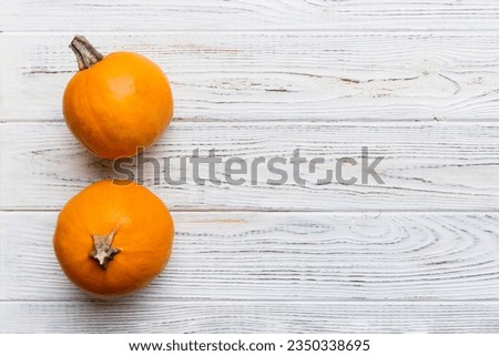Autumn composition of little orange pumpkins on colored table background. Fall, Halloween and Thanksgiving concept. Autumn flat lay photography. Top view vith copy space.