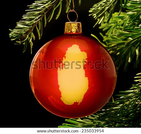 A red bauble with the golden shape of  Qatar hanging on a christmas tree isolated on black.(series)