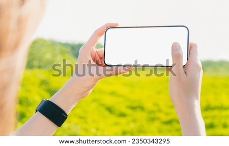 Woman hand holding smartphone with taking photo on garden, Take your screen to put on advertising.