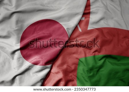 big waving realistic national colorful flag of japan and national flag of oman . macro