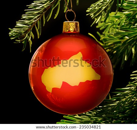 A red bauble with the golden shape of  Central African Republic hanging on a christmas tree isolated on black.(series)