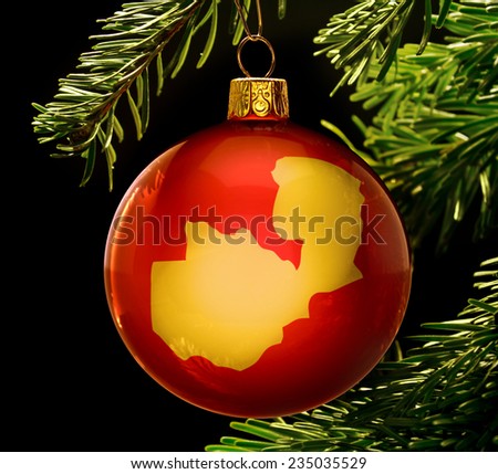 A red bauble with the golden shape of  Zambia hanging on a christmas tree isolated on black.(series)