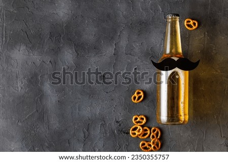 Bottle of beer with moustache with pretzels on grey background. Movember. Concept of a party, father's day, bachelor party.