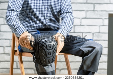 Builder wearing knee protection pads. Concept of safety protective equipment at construction site. Safety at work. Royalty-Free Stock Photo #2350356201
