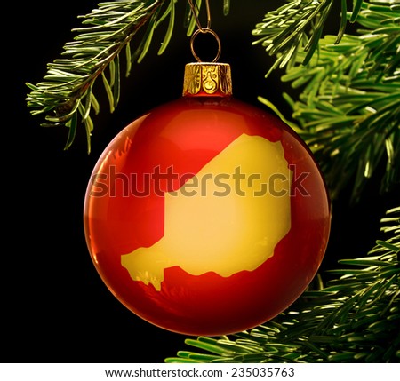 A red bauble with the golden shape of  Niger hanging on a christmas tree isolated on black.(series)