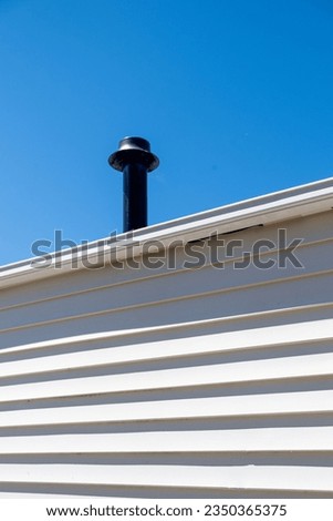 detail of the chimney and wall of a log cabin
