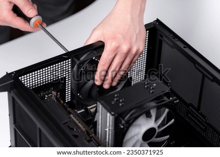 Computer technician installs cooling system of computer. Assembling PC Royalty-Free Stock Photo #2350371925